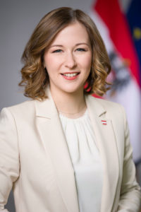 Claudia Bauer Porträt; Portrait einer lächelnden Frau mit hellbraunen Haaren im hellen Blazer.